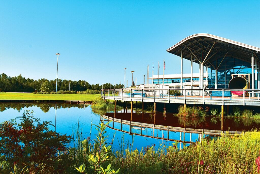 A large building next to a pond and grass.